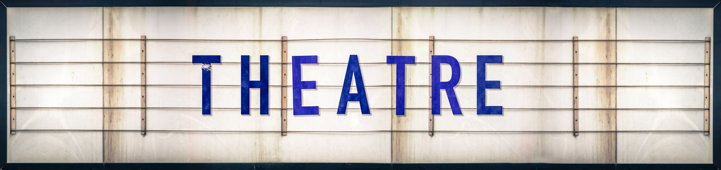 A Grungy Old Weathered Theatre Marquee Sign With Blue Letters