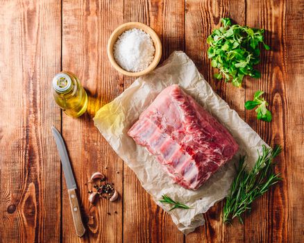 Raw Pork Ribs on Parchment Paper with Different Spices. View from Above.