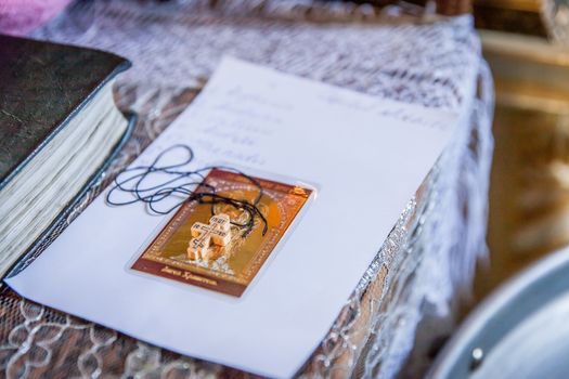 Small wooden cross with Bible on altar during christening