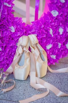 Two ballet shoes on pink decoration with laces