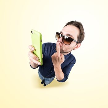 latin lover make a funny face, and take a self portrait with his smart phone