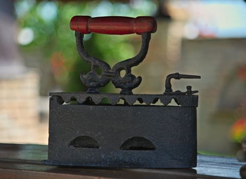 Old vintage iron standing on wooden shelf