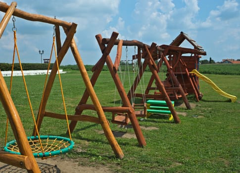 Several children wooden toys in a row on a playground