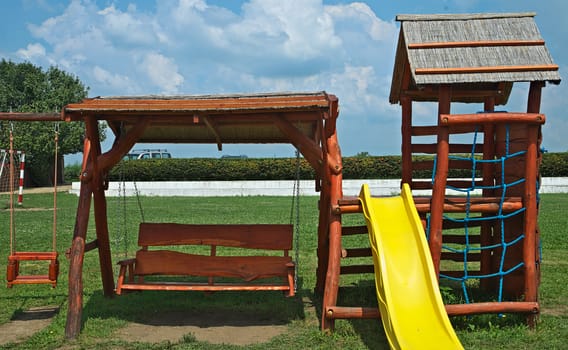 Several children wooden toys in a row on a playground