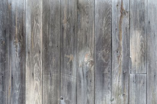 Unpainted gray wooden door consisting of old weathered unpainted boards
