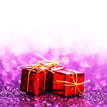Decorated red holiday gifts on glitter background