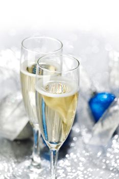 Champagne glasses and new year decoration on silver bokeh background