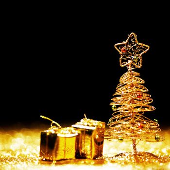 Toy golden decorative Christmas tree on glitter background