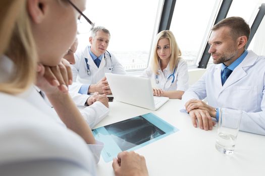 Group of doctors look and discuss x-ray in a clinic or hospital