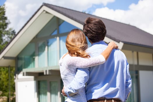 Happy couple walking looking at their house