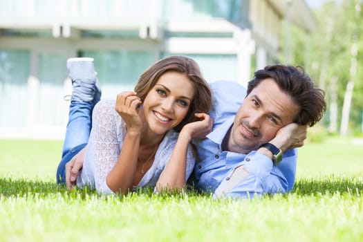 Happy smiling couple laying down in their home garden