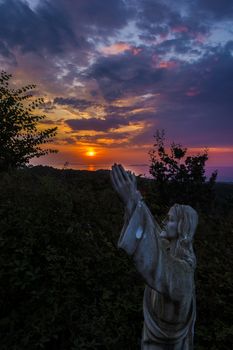 Jesus statue at a beautiful sunset at Corfu - Greece.