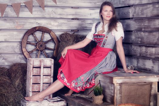 Beautiful woman in traditional german dress on hay