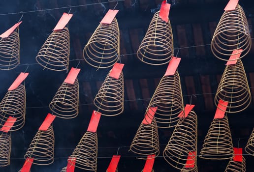 Spiral incense burning hanging from the ceiling in Vietnamese temple