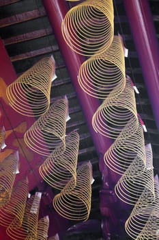 Spiral incense burning hanging from the ceiling in Vietnamese temple