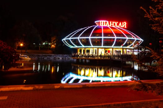 Night city landscape. City ponds Khabarovsk in the light of lanterns, which are reflected in the water.