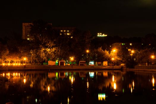 Night city landscape. City ponds Khabarovsk in the light of lanterns, which are reflected in the water.