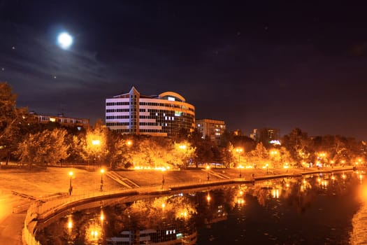 Night city landscape. City ponds Khabarovsk in the light of lanterns, which are reflected in the water.