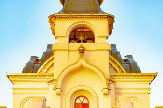 Beautiful view during sunset at the temple of St. Seraphim of Sarov in the city of Khabarovsk. A beautiful green lawn in the foreground. Religious architecture, buildings and traditions. Russia.