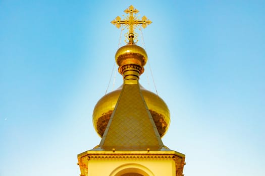 Beautiful view during sunset at the temple of St. Seraphim of Sarov in the city of Khabarovsk. A beautiful green lawn in the foreground. Religious architecture, buildings and traditions. Russia.