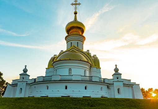 Beautiful view during sunset at the temple of St. Seraphim of Sarov in the city of Khabarovsk. A beautiful green lawn in the foreground. Religious architecture, buildings and traditions. Russia.