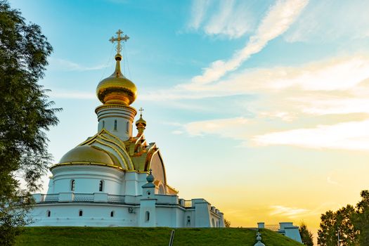 Beautiful view during sunset at the temple of St. Seraphim of Sarov in the city of Khabarovsk. A beautiful green lawn in the foreground. Religious architecture, buildings and traditions. Russia.