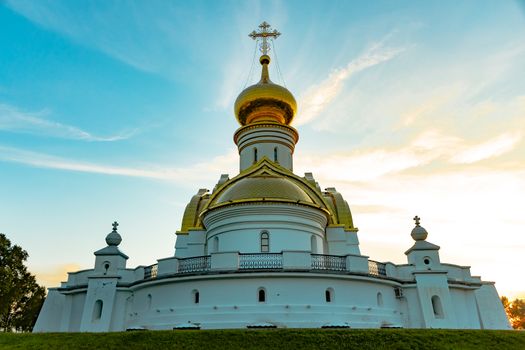 Beautiful view during sunset at the temple of St. Seraphim of Sarov in the city of Khabarovsk. A beautiful green lawn in the foreground. Religious architecture, buildings and traditions. Russia.