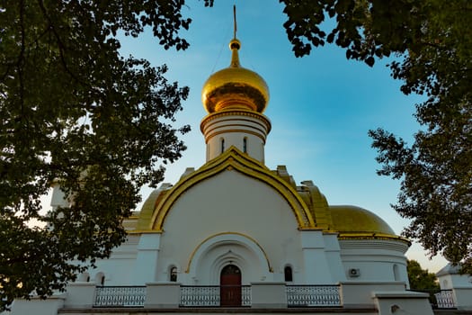 Beautiful view during sunset at the temple of St. Seraphim of Sarov in the city of Khabarovsk. A beautiful green lawn in the foreground. Religious architecture, buildings and traditions. Russia.