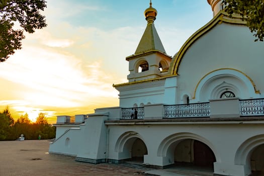 Beautiful view during sunset at the temple of St. Seraphim of Sarov in the city of Khabarovsk. A beautiful green lawn in the foreground. Religious architecture, buildings and traditions. Russia.