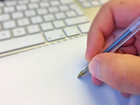 Male hand writing with a pen on blank paper