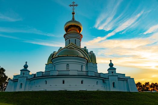 Beautiful view during sunset at the temple of St. Seraphim of Sarov in the city of Khabarovsk. A beautiful green lawn in the foreground. Religious architecture, buildings and traditions. Russia.