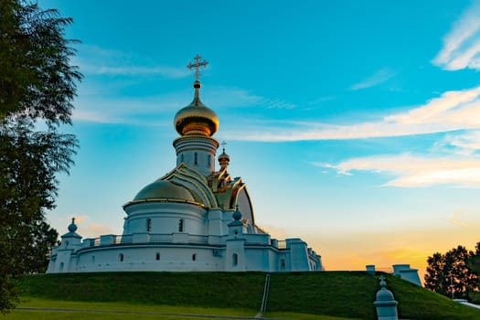 Beautiful view during sunset at the temple of St. Seraphim of Sarov in the city of Khabarovsk. A beautiful green lawn in the foreground. Religious architecture, buildings and traditions. Russia.