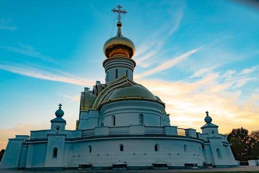 Beautiful view during sunset at the temple of St. Seraphim of Sarov in the city of Khabarovsk. A beautiful green lawn in the foreground. Religious architecture, buildings and traditions. Russia.