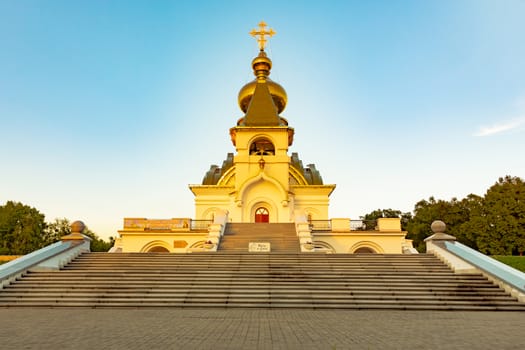 Beautiful view during sunset at the temple of St. Seraphim of Sarov in the city of Khabarovsk. A beautiful green lawn in the foreground. Religious architecture, buildings and traditions. Russia.