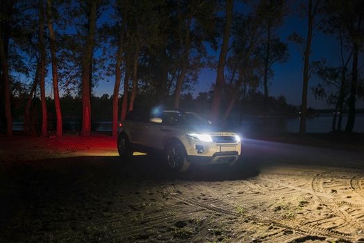 Car Land Rover Range Rover in the summer clear weather in the evening landscape of the Samara region, Russia. August 23, 2018..