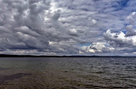 blue sky with powerful cumulonimbus clouds over the lake