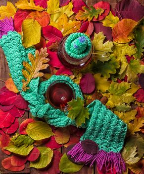 Blurred autumn leaves background with hot steaming cup of tea