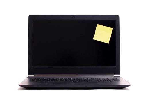 Empty blank post it note on a black laptop, isolated