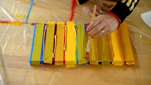 Female artist painting a rainbow with acrylic colors on canvas, hoe made art, DIY tutorial, colorful, painting with gold, tape mask for pattern