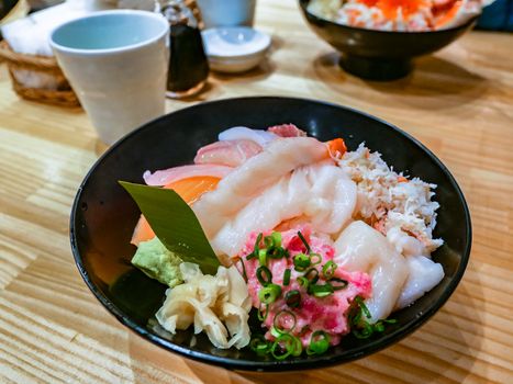 Sasimi food in the bowl on wooden texture,Sashimi of fresh raw Salmon and roe on rice of Japanese tradition food restaurant