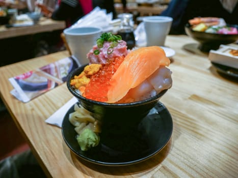 Sasimi food in the bowl on wooden texture,Sashimi of fresh raw Salmon and roe on rice of Japanese tradition food restaurant
