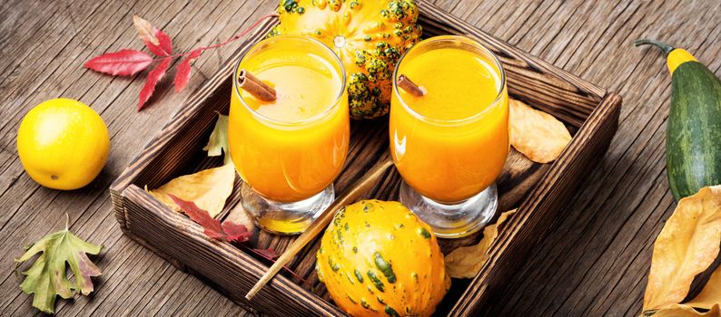 Pumpkin smoothie in a glass on vintage table.Beverage with pumpkins