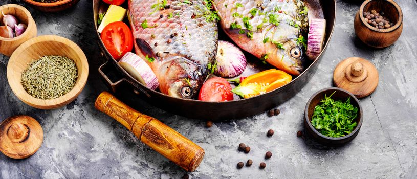Fresh fish carp with ingredients for cooking on pan.Dietary food
