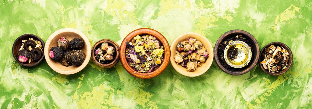Mixture herbal floral tea in a wooden mortar.Dry tea leaves