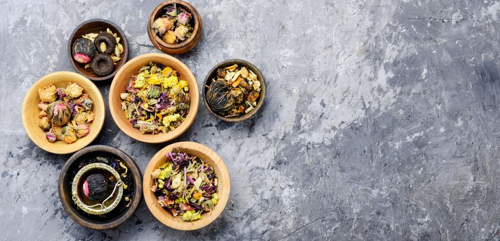 Mixture herbal floral tea in a wooden mortar.Heap of dried tea