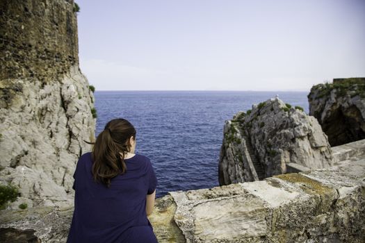 Young woman making photos to the sea, detail of photography and tourism