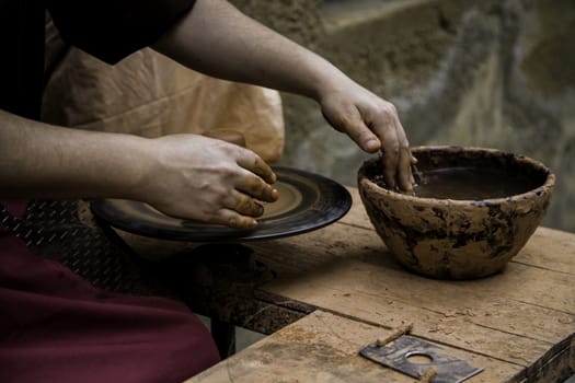 Hands of man working and shaping clay, potter in pottery, craft detail, creation