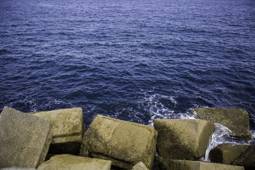 Rocks on a breakwater, sea shore detail