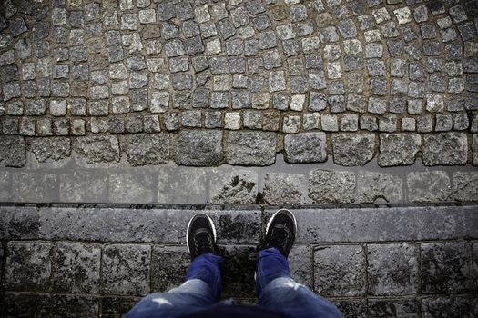 Tourist feet on cobblestones, detail of human feet in Europe