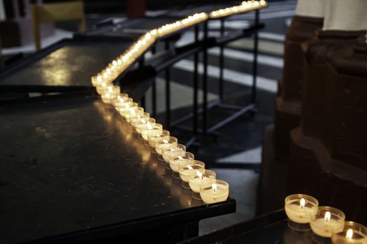 Candles lit in a church, detail of medieval city in Belgium